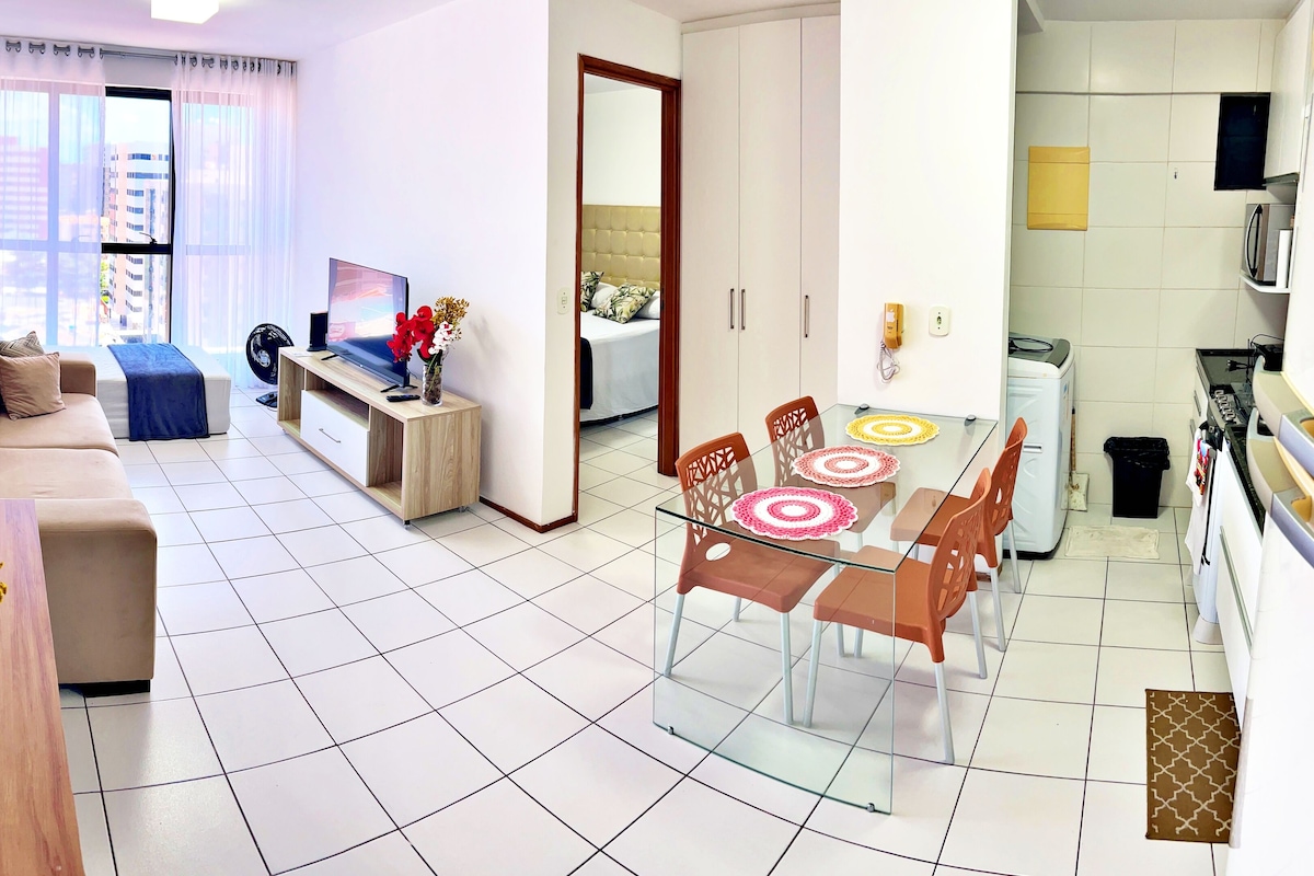 A modern apartment with a living room, dining area, and kitchen.