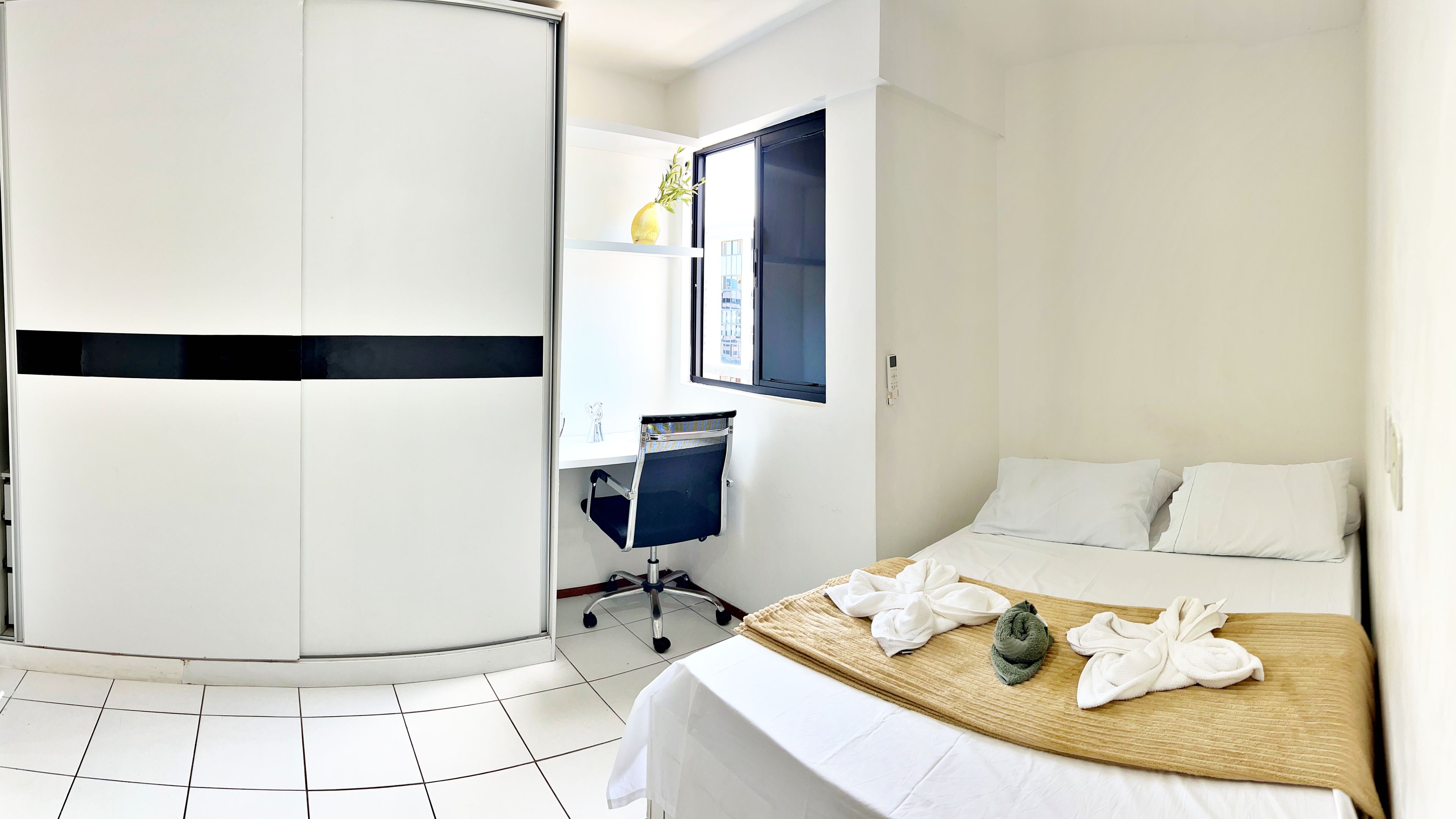 Une chambre d’hôtel avec un lit, un bureau et une chaise.