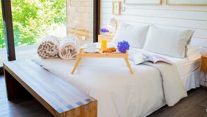 Une chambre à coucher avec un lit, une table de chevet et un banc en bois.