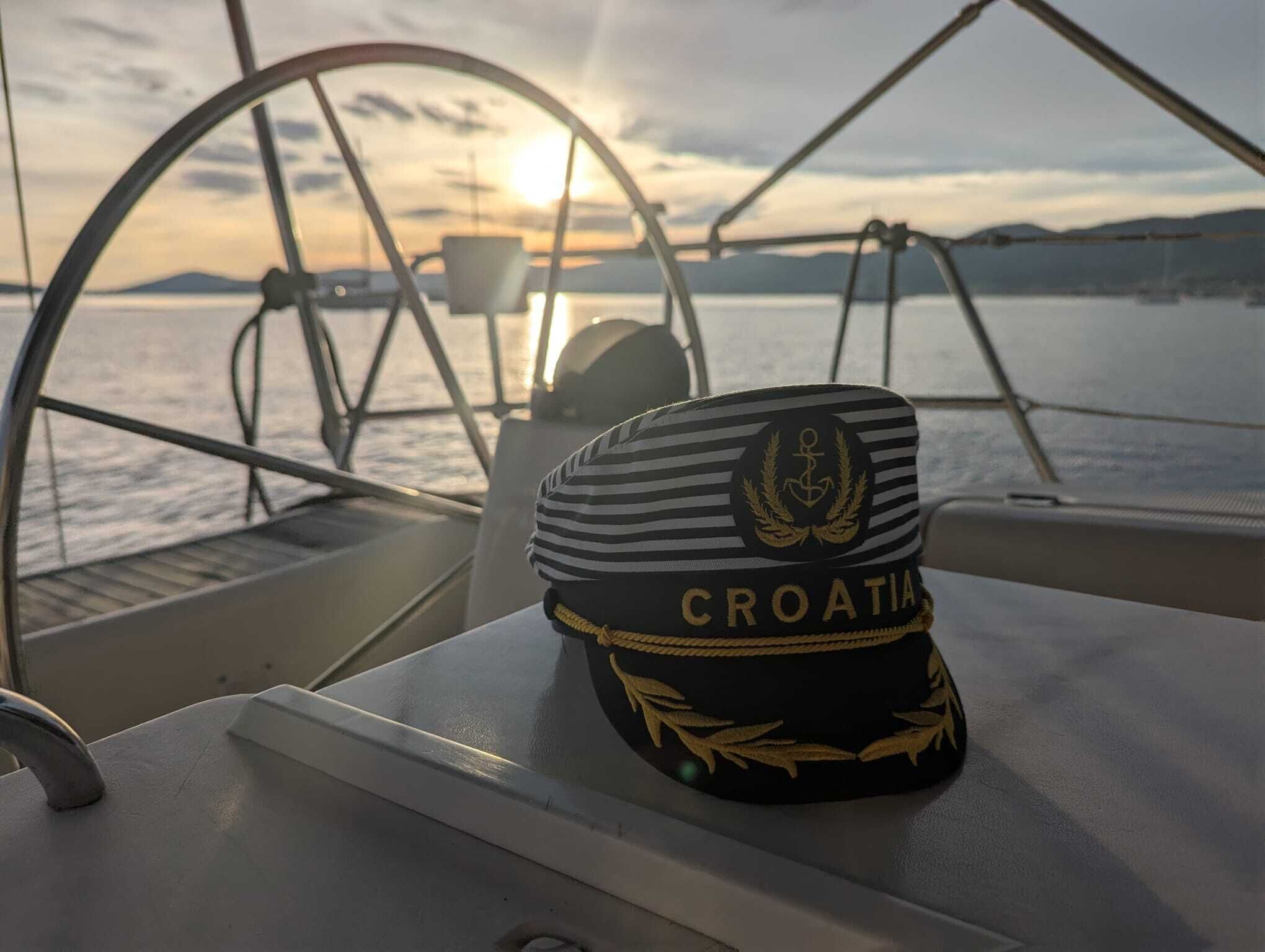 Une casquette rayée avec le mot « CROATIE » inscrit sur le pont d’un bateau.