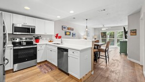 A modern kitchen with white cabinetry, stainless steel appliances, and a central island. - Gulf View~Steps to Sugar White Sands~Pool~Tennis~Private Beach Access~Ciboney 2011 (Destin)