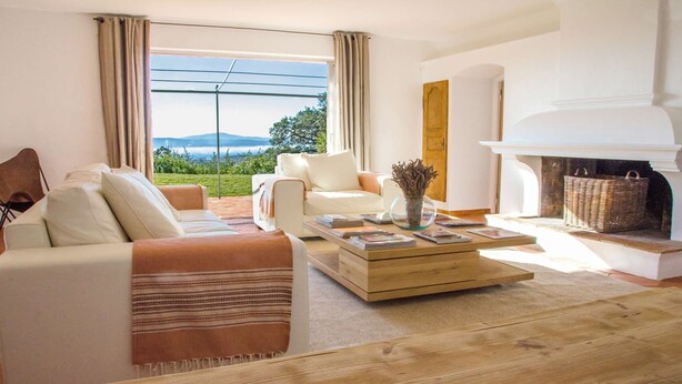 Una sala de estar moderna con un sofá, sillones, una mesa de centro y una chimenea.