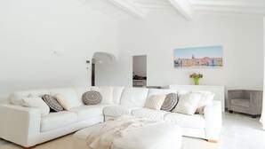 A modern living room with a white sectional sofa, a grey armchair, and a painting of a cityscape on the wall. - Villa for 15 people - Private pool - Air conditioning - WiFi - Sainte Maxime - 5-star rated (STE MAXIME)