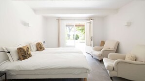 A bedroom with two beds, a chair, and a view through a door. - Villa for 15 people - Private pool - Air conditioning - WiFi - Sainte Maxime - 5-star rated (STE MAXIME)