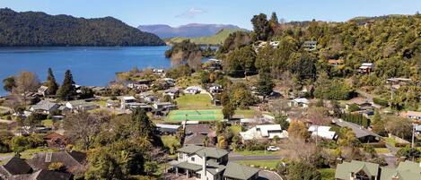 Zona residencial com casas, quadra de tênis e um lago.