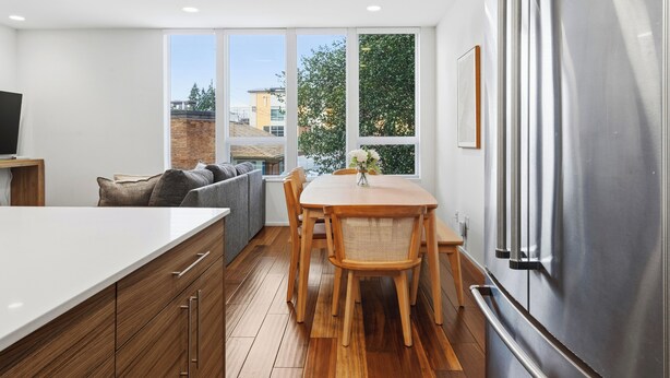 A modern kitchen with a large island, wooden cabinets, and a stainless steel refrigerator. - Rooftop Retreat w/ Stunning Views | Ballard Gem (Seattle)