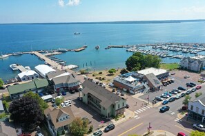 A marina with boats docked, a parking area, and buildings with commercial establishments. - Downtown Bayfield Lodging in Historic Building (Bayfield)