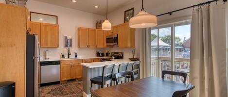 Una cocina moderna con armarios de madera, una isla central e iluminación colgante.