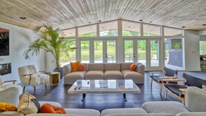 A spacious living area with a large sectional sofa, a coffee table, and a potted plant. - Amazing 5 bdrms, 4 bath, private lake house, + guest house, 20 min from Atlanta (Fayetteville)
