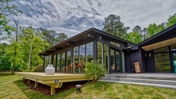 A modern house with large glass windows, a wooden deck, and a small garden. - Amazing 5 bdrms, 4 bath, private lake house, + guest house, 20 min from Atlanta (Fayetteville)