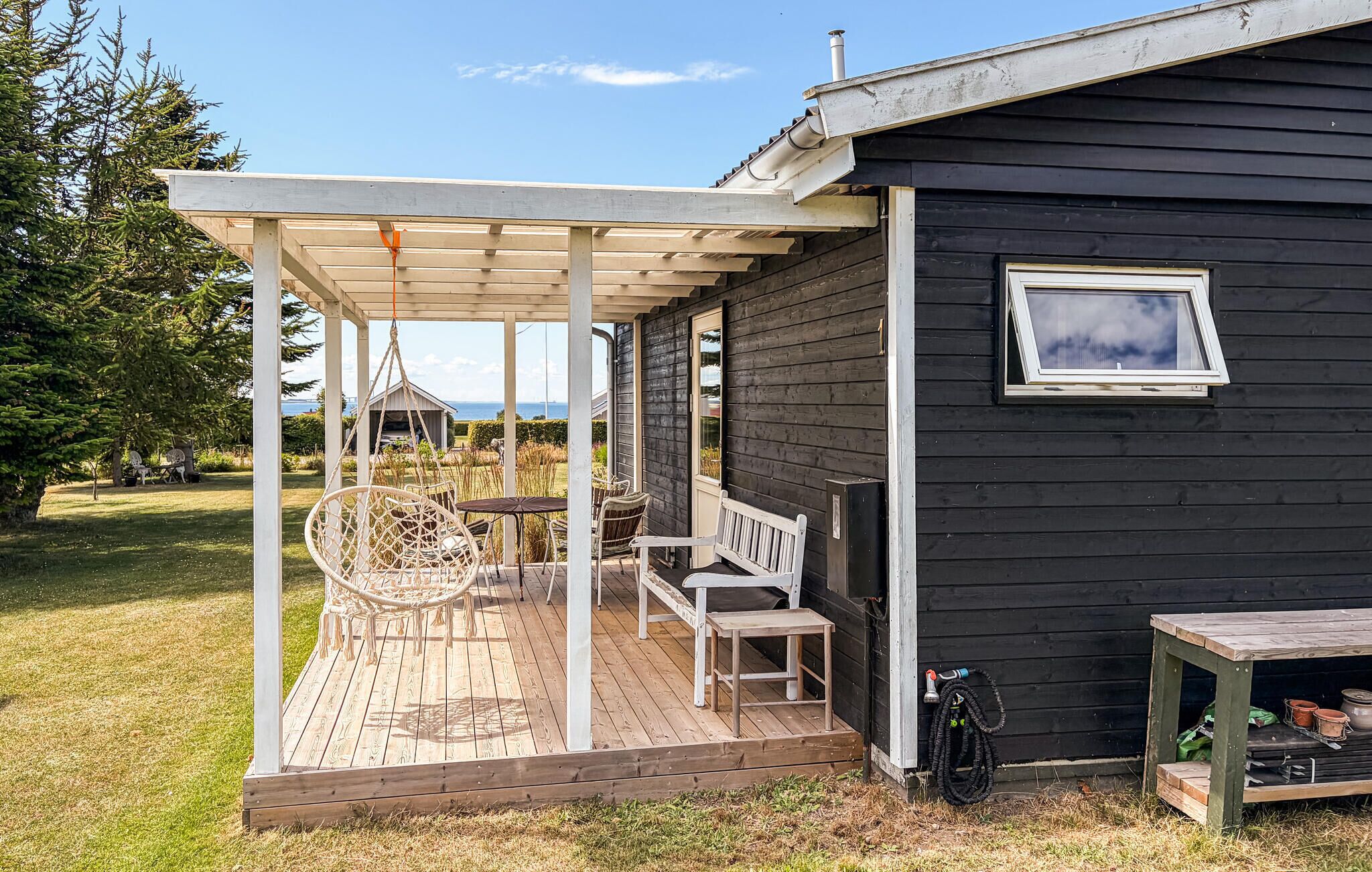 A wooden deck with outdoor furniture, a covered seating area, and a view of the landscape.