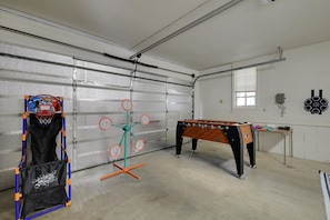 A garage with a basketball hoop, a foosball table, and a table tennis table. - Pine Grove Retreat for 10 | Game Room + Fire Pit (Pine Grove)