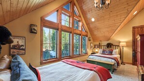Ein geräumiges Schlafzimmer mit großen Fenstern, einer Holzbalkendecke und einer gemütlichen Atmosphäre.