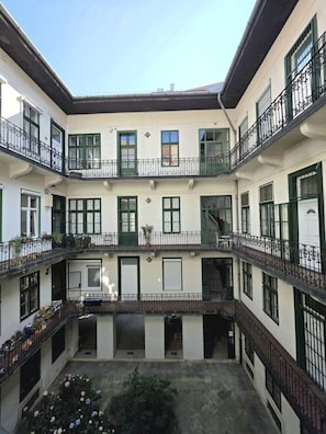 Ein mehrstöckiges Gebäude mit Balkonen, großen Fenstern und einem Innenhof.