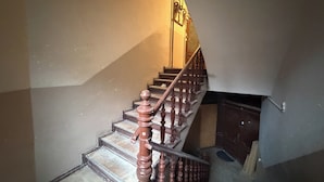 A staircase with wooden balusters and a handrail, leading to a landing with a door. - Słowackiego Serene Studio with Balcony (Katowice)