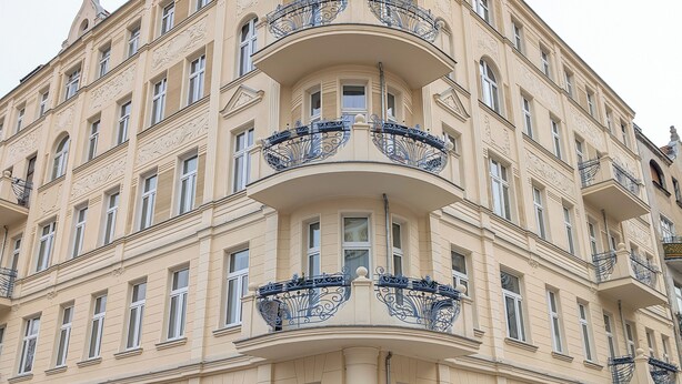 Un edificio de varios pisos con balcones ornamentados y un estilo arquitectónico clásico.