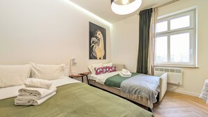 Habitación de hotel con dos camas, un cuadro en la pared, una ventana con cortinas y un radiador.