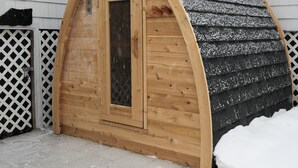 A wooden arched structure with a door, surrounded by snow. - Soothing 2-bedroom cottage with Sauna in Old Orchard Beach (Old Orchard Beach)