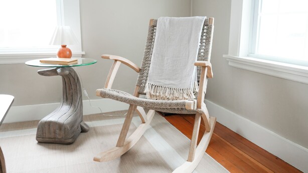 A rocking chair with a white towel, a glass table with a vase, and a lamp. - Soothing 2-bedroom cottage with Sauna in Old Orchard Beach (Old Orchard Beach)