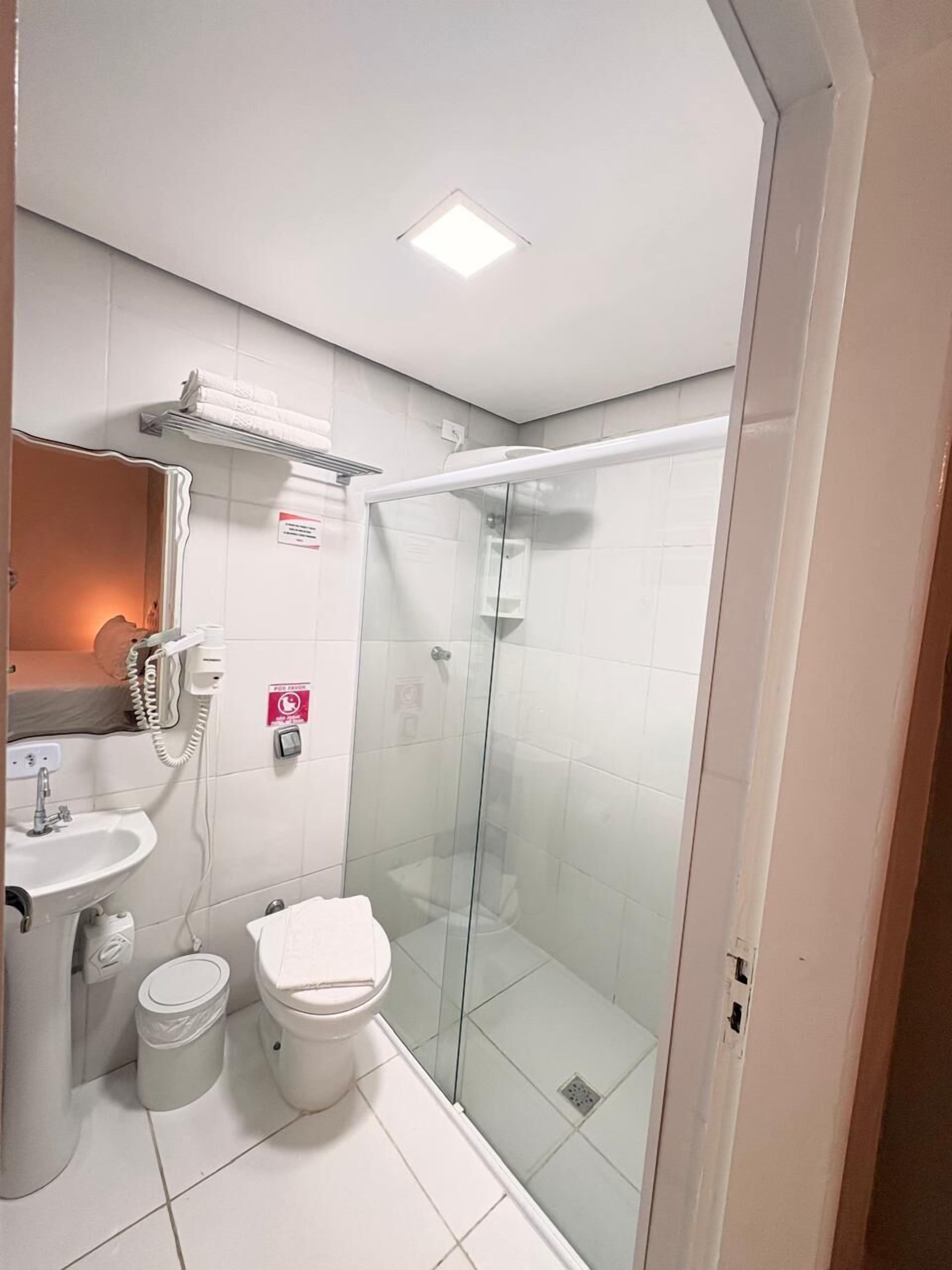 Ein modernes Badezimmer mit einer Duschkabine, einem Waschbecken und einer Toilette.
