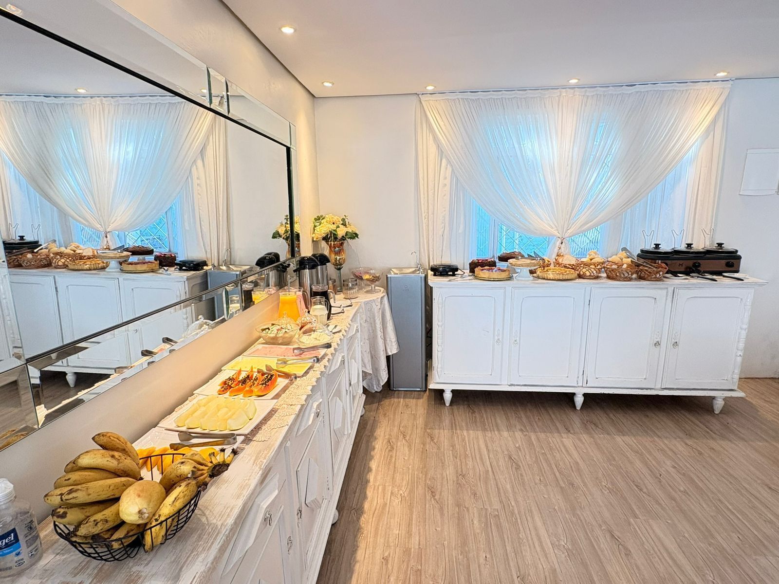Una mesa de buffet con diversos alimentos y una cesta de frutas.