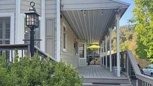 Une maison à deux étages avec un porche couvert, une boîte aux lettres et un lampadaire.