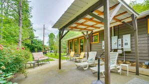 A covered patio area with outdoor seating, including chairs and a table, and a fire pit. - Absolute Humble Abode, Condo, Sleeps 4, Mins from Dollywood! (Pigeon Forge)