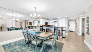 A modern kitchen with a central island, white cabinetry, and a chandelier. - Gulf Front-Amazing Views! Close to Dining & Shopping Crystal Dunes 404 (Destin)