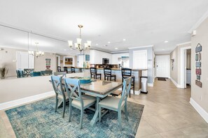 A modern kitchen with a central island, white cabinetry, and a chandelier. - Gulf Front-Amazing Views! Close to Dining & Shopping Crystal Dunes 404 (Destin)