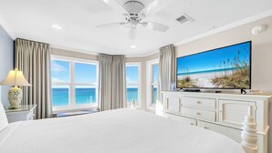 A large bed with a view of the ocean, a ceiling fan, a flat-screen TV, and a dresser. - Gulf Front-Amazing Views! Close to Dining & Shopping Crystal Dunes 404 (Destin)