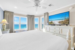 A large bed with a view of the ocean, a ceiling fan, a flat-screen TV, and a dresser. - Gulf Front-Amazing Views! Close to Dining & Shopping Crystal Dunes 404 (Destin)