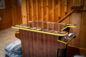 Ein hölzerner Arcade-Automat mit Glasabdeckung und bunten Spiele-Icons.