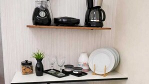 A kitchenette with a blender, coffee maker, and a small refrigerator. - Practical and cozy house in Vila Velha (2 guests) (Vila Velha)