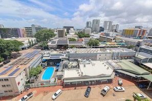 A commercial building with multiple floors, a rooftop pool, and solar panels. - Top Floor Tropical Escape | Pool | King Bed | Balcony (Darwin City)