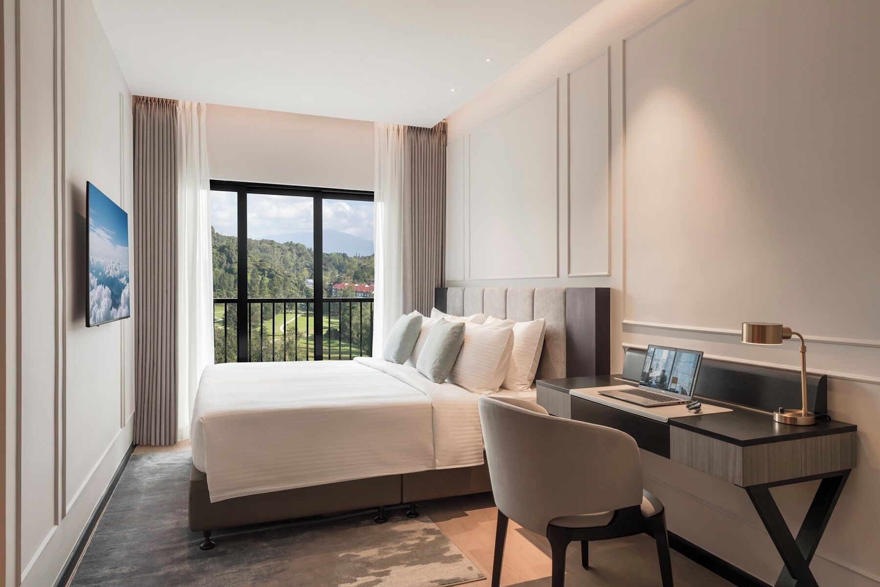 Habitación de hotel con cama, escritorio, silla, televisión y ventana con vistas al paisaje.