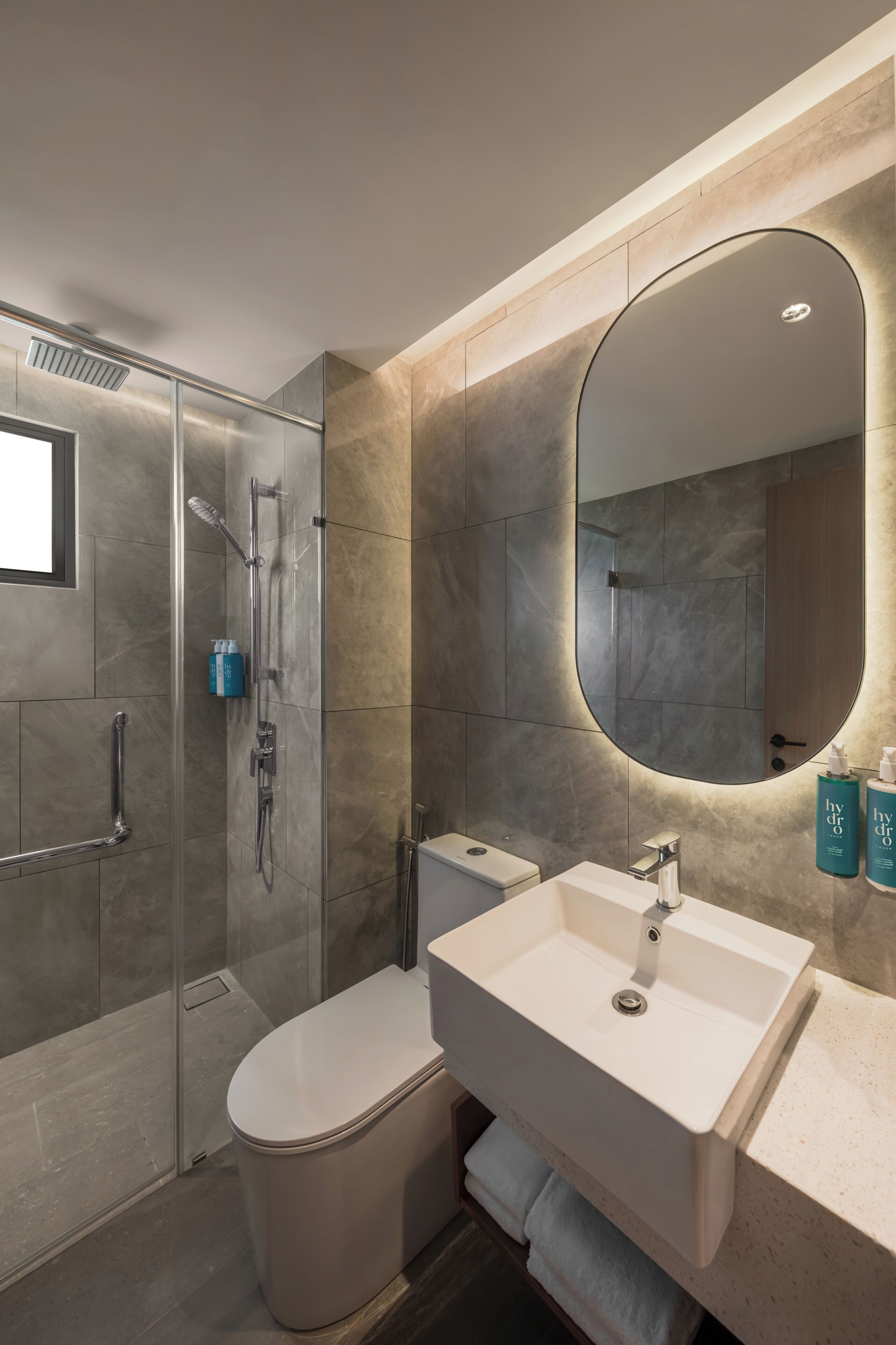 Un bagno moderno con doccia vetrata, lavandino bianco e uno specchio grande.