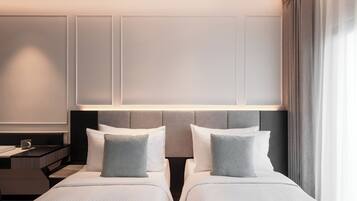 Une chambre d’hôtel avec deux lits, une table de chevet et une commode.