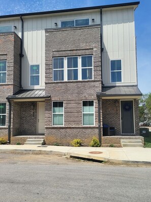A multi-story building with a brick facade and white trim. - Pet-Friendly Townhouse with Free Parking in TN (Chattanooga)