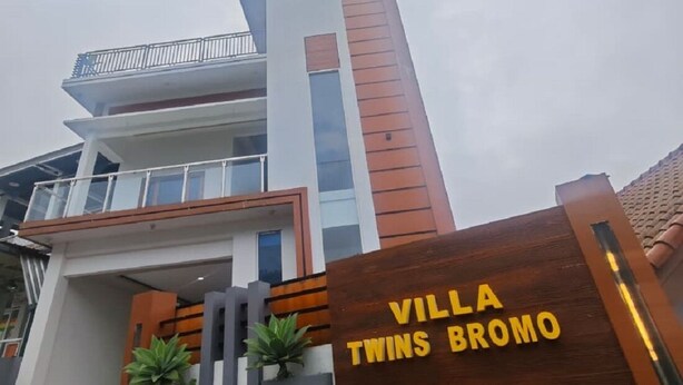 Een moderne villa met een opvallend bord waarop 'Villa Twins Bromo' staat.
