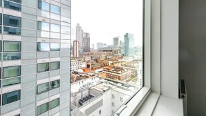 Ein Hochhaus mit Blick auf eine Stadtlandschaft durch ein Fenster.