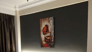 A hotel room with two beds, a painting on the wall, and a bedside table with a lamp. - Hotel Casamas (Malacca City)