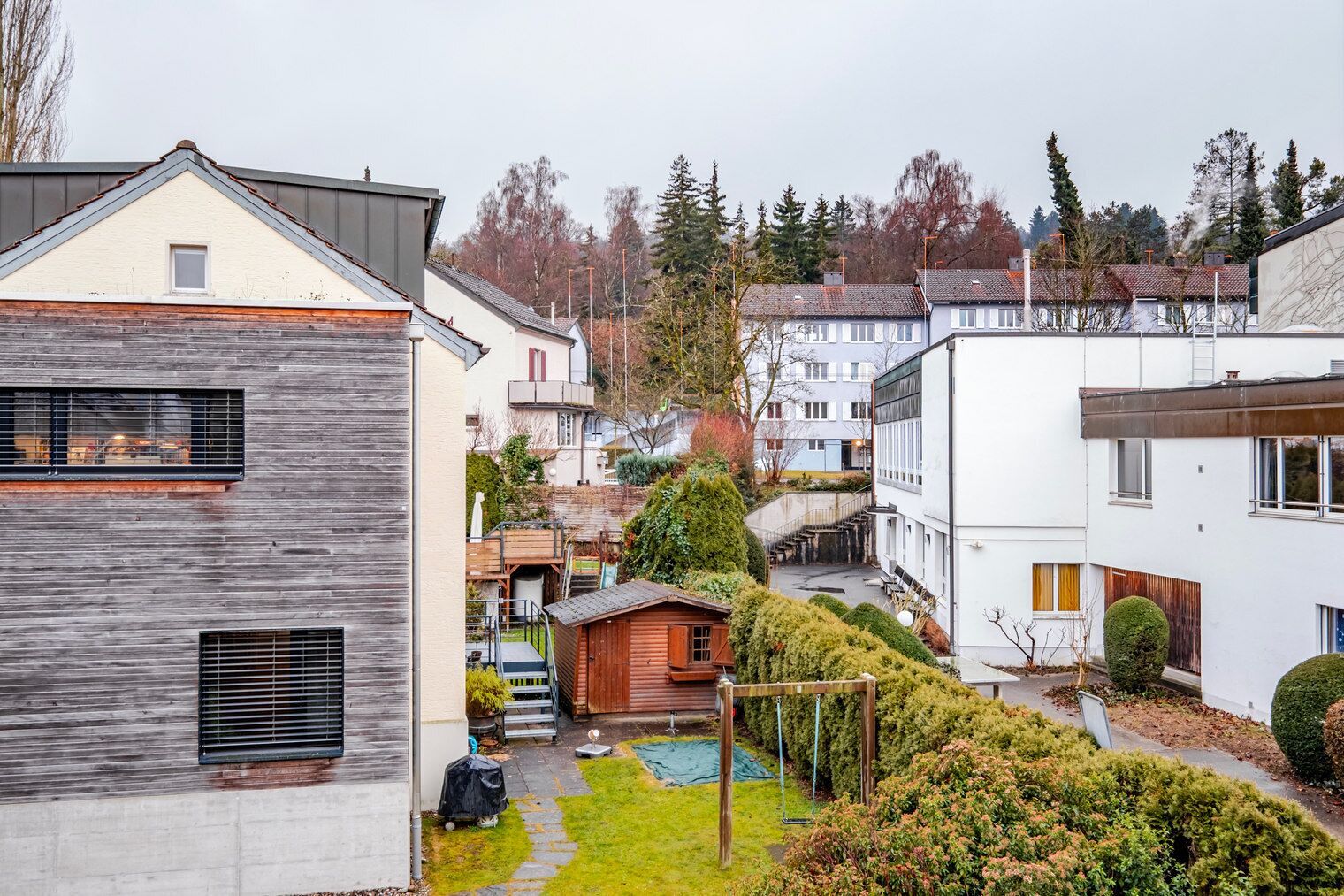 A residential area with modern houses, a wooden deck, and a small garden.