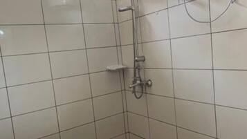 A bathroom with a shower, a toilet, and a water heater.
