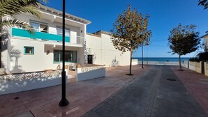 Een modern gebouw met balkon, terras en uitzicht op zee.