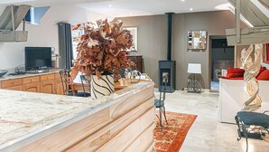 Ein modernes Wohnzimmer mit einer Holztrennwand, einem Kamin und einer großen Zimmerpflanze.