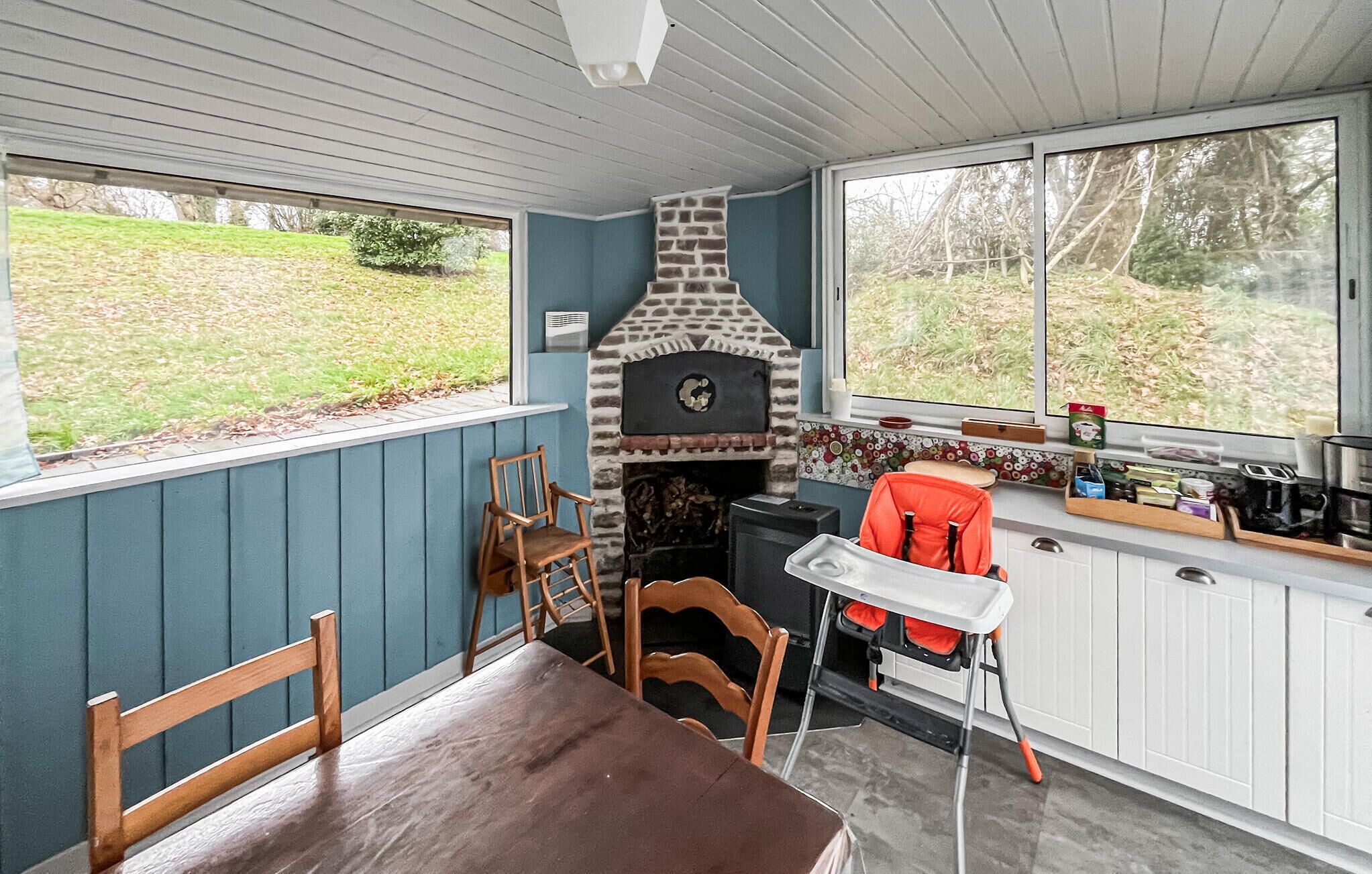 Una cucina accogliente con camino in pietra, sedie di legno e tavolo da pranzo.