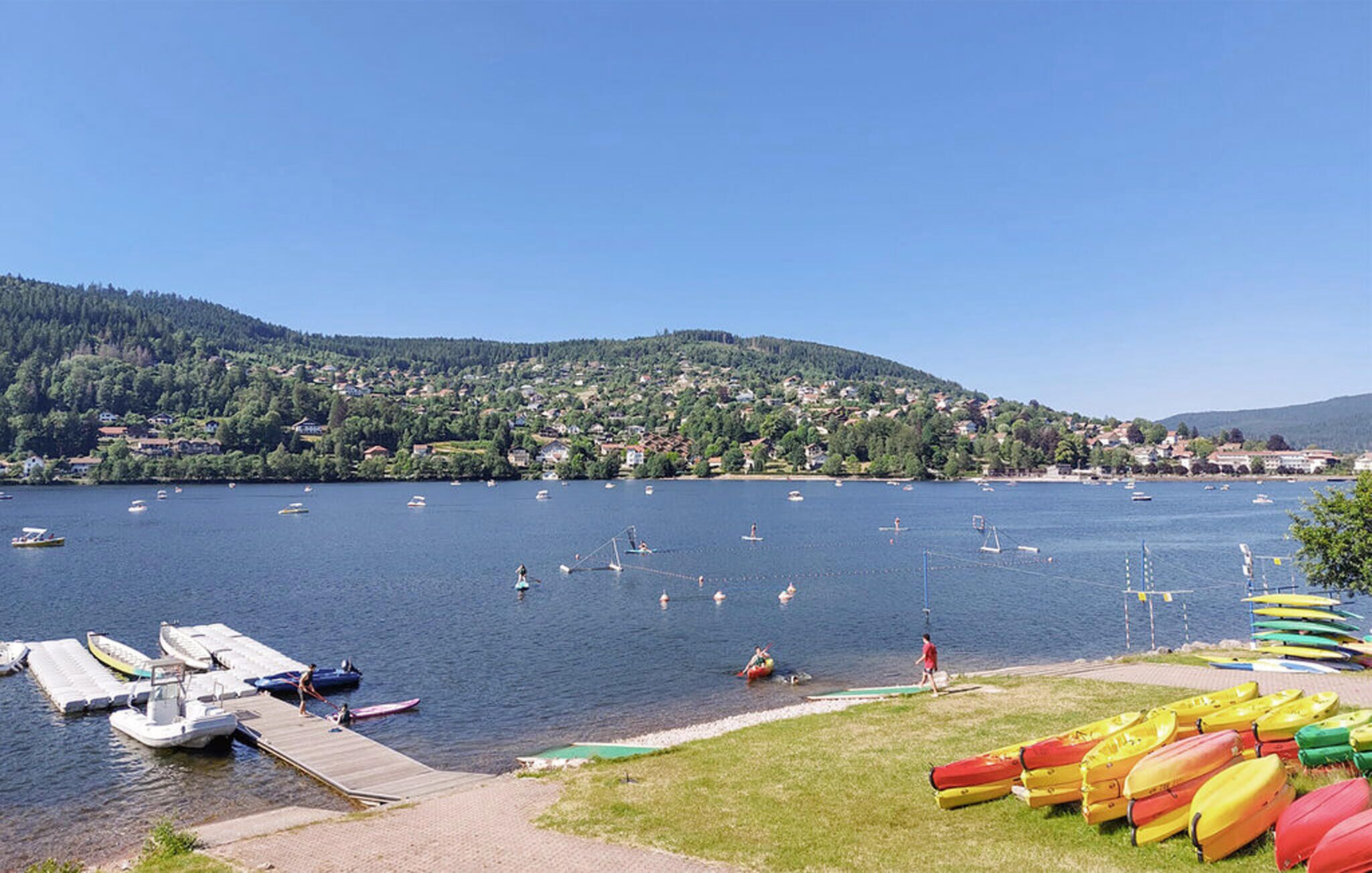 Une vue sur le lac, avec des bateaux, un quai et une rangée de canoës.