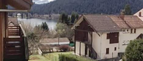Una zona residencial con casas, una masa de agua y una colina al fondo.