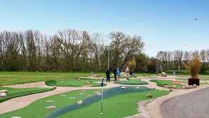 Ein Minigolfplatz mit kurvigen Bahnen, Sandfällen und einem Wasserschutzgebiet.