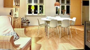 Eine moderne Küche mit Esstisch, Stühlen und einem eingebauten Backofen.